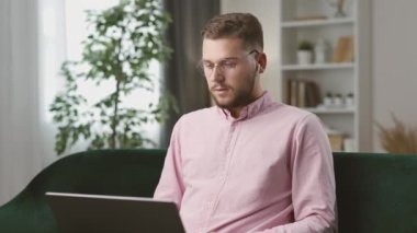 Kanepede oturan yakışıklı adam ortaklarla iş projesini tartışıyor. Uzak iletişim.