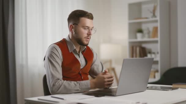 英俊的男子决定坐在办公桌前 在笔记本电脑前进行视频聊天 现代企业家 遥远的公司员工通过视频通话进行商务会议 — 图库视频影像