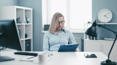 Olgun, neşeli, ofis işlerinden bitap düşmüş, yorgun ve aşırı yanmış, rutin işlerden bunalmış bir kadın.