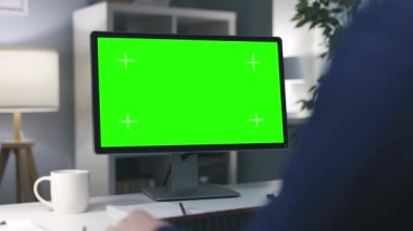 İş adamı boş bir bilgisayar ekranında video konferansı yapıyor. Akşam işyerinde bir fincan sıcak kahve içiyor.