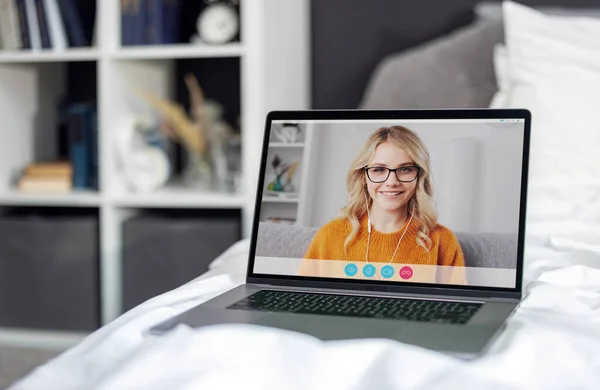 白いリネンと快適なベッドの上に立って画面上の若い女性のビデオ通話とノートパソコン 自宅で現代的なガジェットを使用しています 技術接続の概念 — ストック写真