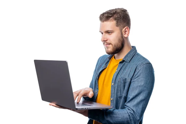 身着黄色休闲装 头戴白色背景笔记本电脑的年轻高加索男性 免版税图库照片