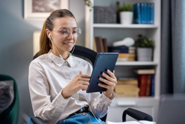 Tablet kullanan neşeli genç bir kadın, neşeli bir kadın internette geziniyor.