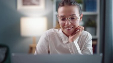 Gülümseyen iş kadını gözlük ve beyaz gömlek takıyor, dizüstü bilgisayarda geziniyor, ön statik görüş