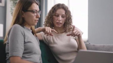 Kanepede dizüstü bilgisayarda gezinen iki arkadaş, kıvırcık kadın arkadaşının gözlüklü halini açıklıyor ve internette bunu arıyor.