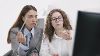 Verilerle çalışan iki kadın, kadın yönetici, stajyer öğrencilere bilgisayar eğitimi veriyor, patron, ofiste çalışan işçilere projeyi anlatıyor.