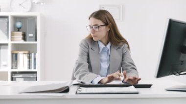 Ofiste bilgisayarda yazı yazan meşgul bir iş kadını. Derin bir iç çekiş ve kaşlarını çatma. Belgelerde can sıkıcı bir şekilde bilgi arıyor.