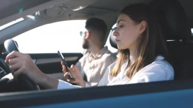 Akıllı telefon bağımlısı kadın sosyal medyayı direksiyona kaydırıyor yola odaklanamıyor, başka bir araca çarpıyor, kazaya neden oluyor.