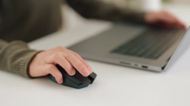 Kadınların ellerinin yakın plan videosu, bilgisayar faresi, kaydırma ve kaydırma tuşları kullanıyor ve masadaki dizüstü bilgisayarla ekrandaki seçili ögeleri kullanıyor