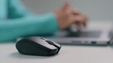 Yakın çekim videosu, kadınlar masadaki dizüstü bilgisayarda çalışırken bilgisayar faresini kaydırmak, tuşlara ve klavyeye tıklamak için kullanır
