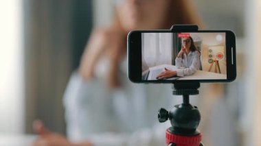 Kadının telefon görüntüsü kameraya konuşurken koç gibi canlı yayın yapan video bloğu videolarında değerli bilgiler paylaşıyor.
