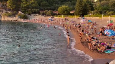 Bu video Adriyatik Denizi üzerinde güzel bir gün batımını gösteriyor. Sahil sıcak akşamın tadını çıkaran insanlarla dolu. Su sakin ve berrak, kum da yumuşak ve beyaz. Sahne mükemmel.
