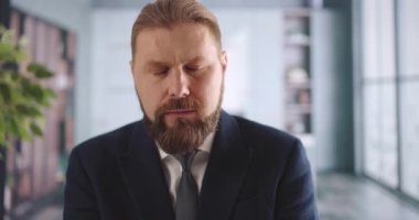 Ofis masasında oturan ve uykulu hisseden ilk yetişkin sakallı adam. Şık takım elbiseli ve kravatlı beyaz iş adamı aşırı çalışmaktan yoruldu..