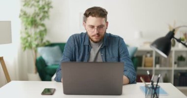 Kafkas yazılım geliştiricisi evden uzakta çalışırken günlük kıyafet programlama kodları kullanıyor. Konsantre adam yeni projesi için görevlerini yerine getiriyor..