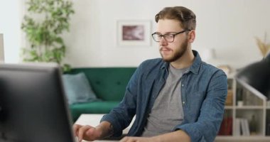 Kafkas kodlama uzmanı. Ev içi iş yerinde oturmuş modern bilgisayarda yazı yazıyor. Erkek programcı evde konsantre bir şekilde çalışıyor. Uzaklaştır.