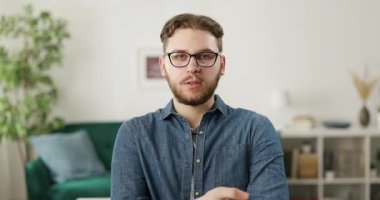 Kafkasyalı sakallı bir adamın rahat koltukta oturması, konuşması ve kendinden emin bir şekilde el kol hareketi yapması. İnsan kavramı ve çevrimiçi iletişim.