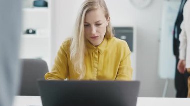 Laptopta yazan olgun odaklı bir kadın. Kalabalık bir ofiste çalışan bir iş kadını. Odaklanma kavramı