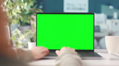 Evden dizüstü bilgisayarla çalışan bir kadın, kroma kopyalama alanı olan bir bilgisayar ekranı, bir fincan dumanı tüten kahveyle samimi bir iç mekan.