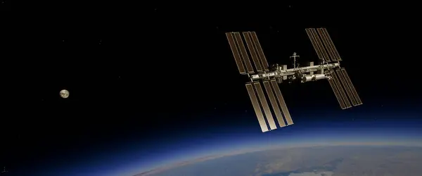 Uluslararası Uzay İstasyonu, Dünya 'nın atmosferine ve uzayına karşı siluetlendi. Arka planda güneş panelleri görünür ve parlak güneş ışığı vardı.. 