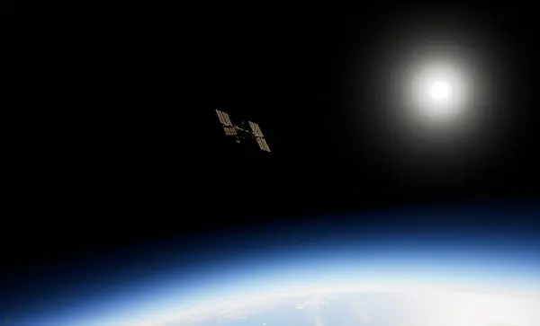 Uluslararası Uzay İstasyonu, Dünya 'nın atmosferine ve uzayına karşı siluetlendi. Arka planda güneş panelleri görünür ve parlak güneş ışığı vardı.. 