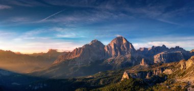 Güneş ışınlarıyla güzel dağ manzarası, şafakta bulutlarla ve kayalarla mavi gökyüzü. Dolomites, İtalya 'daki Tre Cime parkı. İtalyan Alpleri
