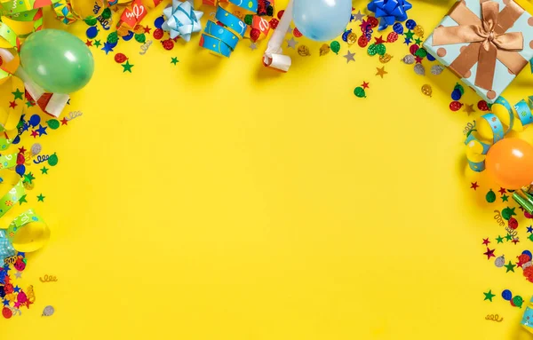 誕生日の背景トップビュー 黄色の背景に風船や様々なパーティーの装飾のフレーム — ストック写真