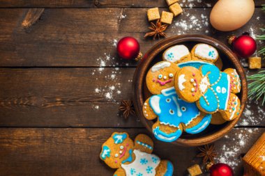 Top view of Christmas baking essentials with gingerbread cookies, rolling pin, eggs, and spices on a wooden background with copy space. Holiday recipes, festive themes, and food blogs clipart