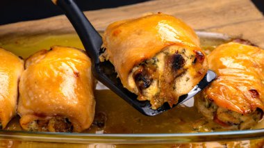 Peynir ve mantarla doldurulmuş fırında pişirilmiş tavuk buğulama kabını kapayın.