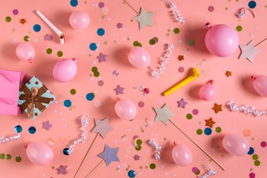 Pembe balonlar, hediye kutuları, konfetiler, yıldız asaları ve pembe arka plan manzaralı parti eşyaları. Doğum günü veya kutlama kavramı