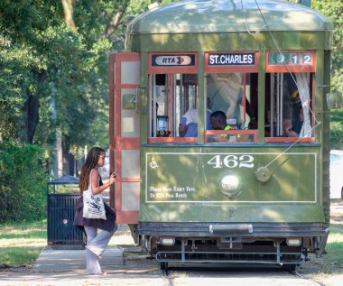 New Orleans, LA, ABD - 18 Ağustos 2023 S. Carrollton Caddesi ve Oak Caddesi 'nin köşesindeki tarihi St. Charles Line tramvayına binen kadın. 