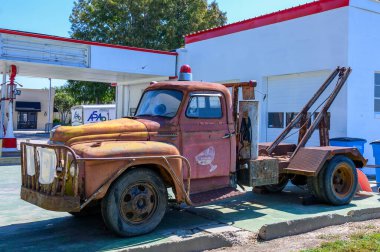 NEW YOADS, LA, ABD - 19 Eylül 2023: 1950 'lerin paslı Uluslararası L-160 çekicisinin retro benzin istasyonunun önündeki görüntüsü 