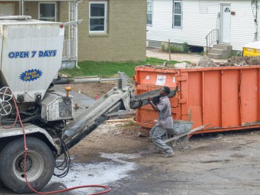 YENİ ORLEANS, LA - 20 HAZİRAN 2008: Gentilly Mahallesi 'ndeki kaldırım projesinde çimento kamyonu ve çöp konteynırı ile çimento işçisi