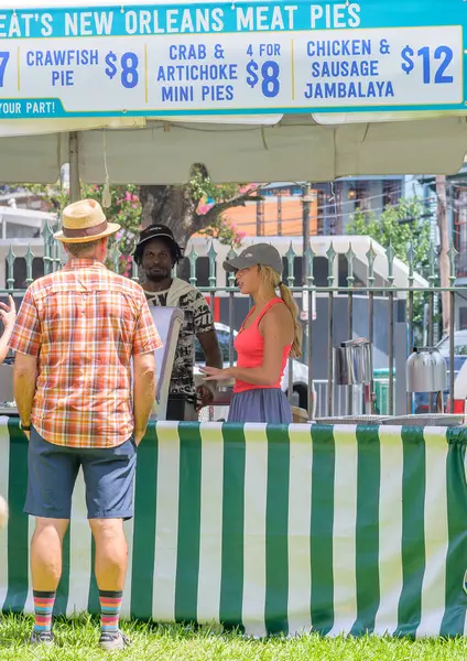 stock image NEW ORLEANS, LA, USA - AUGUST 4, 2024: Customer and vendors at Mrs. Wheat's Meat Pie food booth at Satchmo Summerfest in the French Quarter