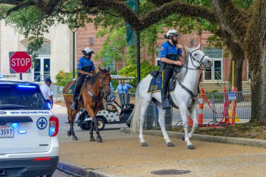 NEW ORLEANS, LA, ABD - 13 AĞUSTOS 2024: Tulane Üniversitesi kampüsünde at sırtında bir çift polis Başkan Joe Biden için konvoyu bekliyor