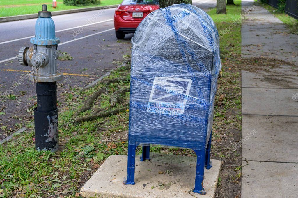 NEW ORLEANS, LA, USA - SEPTEMBER 12, 2024: U.S. Postal Service curbside mailbox wrapped in plastic to waterproof it for Hurricane Francine