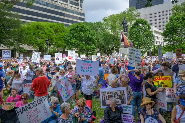 New Orleans, LA, ABD - 5 Nisan 2025: New Orleans şehir merkezindeki Lafayette Meydanı 'ndaki Ulusal Eller Kapalı gösteride işaretli ve bayrak taşıyan protestocular kalabalığı
