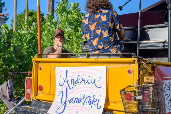 New Orleans, LA, ABD - 27 Ekim 2024: Andriu Yanovski sarı bir kamyonetin arkasında piyano çalıyor ve Revivalistlerin baş adamı David Shaw, Oak Street Poboy Festivali 'nde şarkı söylüyor.