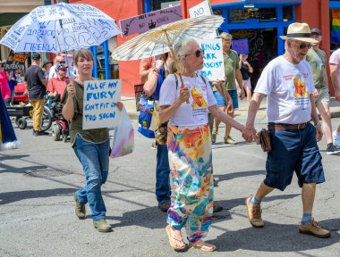 New Orleans, LA, ABD - 14 Haziran 2025: Marigny Mahallesi 'ndeki Fransız Mahallesi' nde Krallar Günü Geçidi 'nde pankartlı, şemsiyeli ve Trump karşıtı göstericilerin yaş ve cinsiyet çeşitliliği