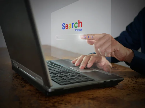 A man is using a notebook computer to searching for information. The Search website on a virtual screen for finding data on the internet. Global network, search engine optimization, information