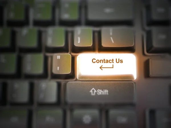 A glowing bright \'contact us\' button, key, message on the keyboard. Customer service concept. Internet or online contact for services and businesses.
