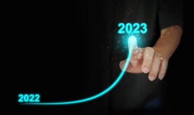 A man's finger draws an upwards curved line from 2022 to 2023. New Year, Christmas, start-up, new business, setting a personal goal