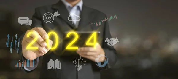 2024年解锁成功 一位商人指出了2024年的发光文字 周围都是相关的商业图标 — 图库照片