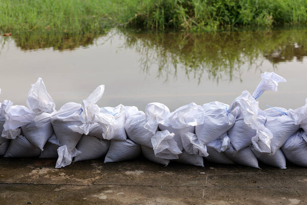 Sandbag for flood protection. A pile or wall of sandbags at the front gate or entrance to keep the house from  flooded water, flooding