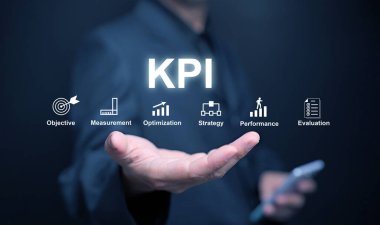 KPI anahtar performans göstergesi. Bir işadamı, elinde KPI 'leri, hedeflerine ulaşmak için iş, proje veya zaman içinde çalışmalarını ölçmek için kullanır.