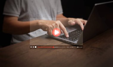 Online video izlemek artık günlük hayatta gömülü. Bir adam dizüstü bilgisayarından eğlence için videolar izliyor. Filmler, canlı gösteriler, online dersler ve müzik de dahil.