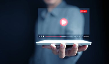 Online video izlemek artık günlük hayatta gömülü. Bir adam eğlence için tabletinden canlı yayın yapan bir video izliyor. Filmler, canlı gösteriler, online dersler ve müzik de dahil.