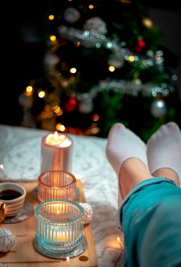 Şöminenin arka planında Noel süsleri olan kadın.