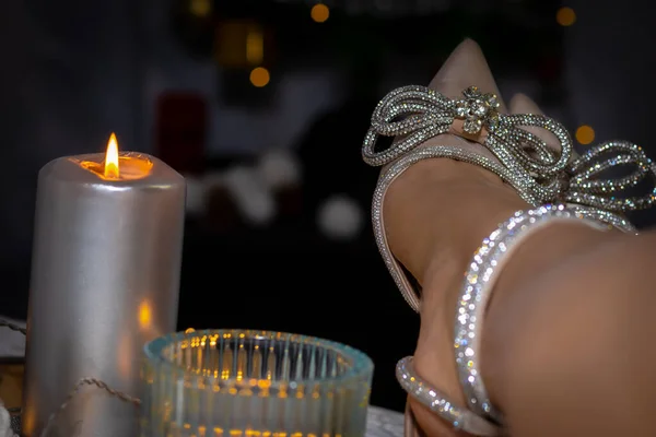 Mumlu Noel süsü ve ayakkabılı kadın bacakları.