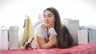 Portrait of smiling woman with shopping bags and credit card