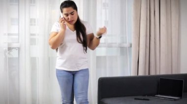 the girl is talking on the phone and solving banking issues, the girl is holding a phone and a bank card and talking